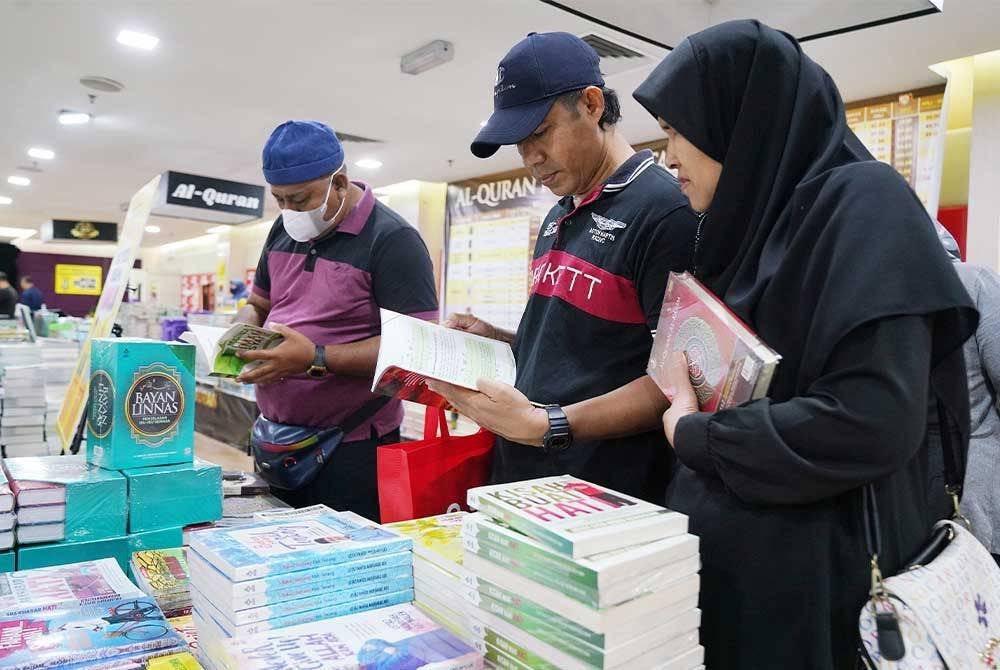 Orang ramai sedang memilih bahan bacaan yang dijual sempena Jualan Gudang Karangkraf 2023 di Kompleks Karangkraf.