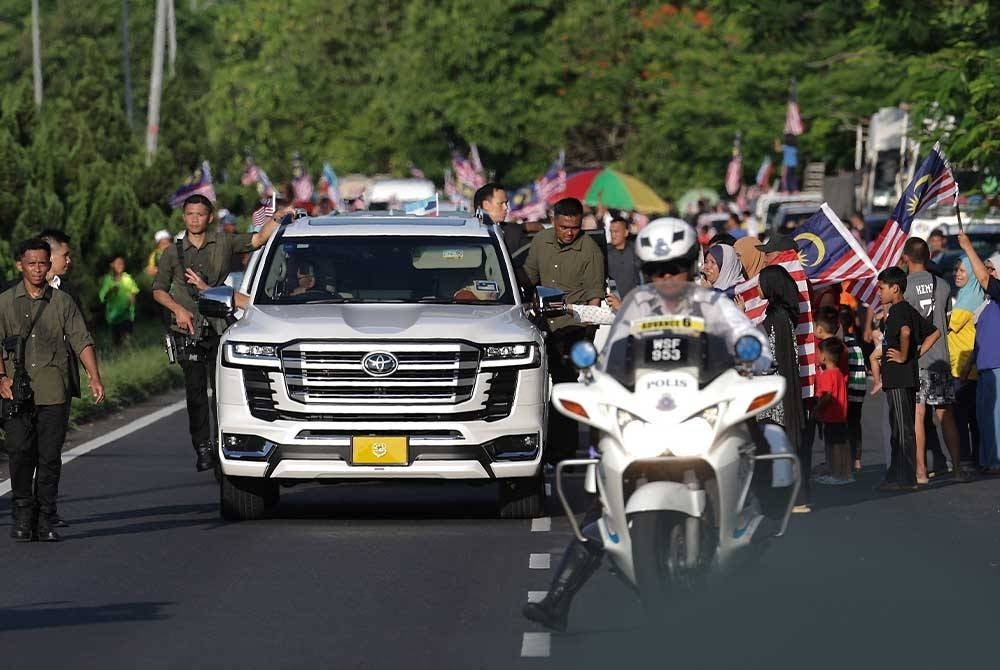 Kenderaan yang dipandu Al-Sultan Abdullah dan Tunku Azizah dikerumuni orang ramai. - Foto Bernama