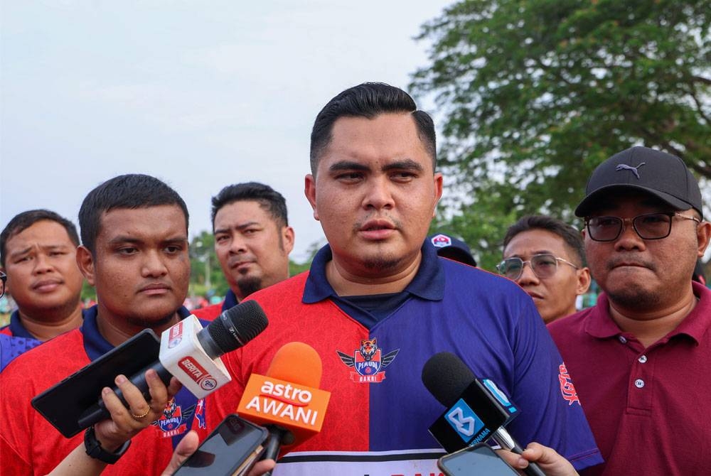Muhammad Akmal (tengah) mengadakan sidang akhbar selepas menghadiri perlawanan bola sepak bersama komuniti belia Simpang Jeram di Padang Kampung Kenangan Tun Dr Ismail 2 pada Ahad. - Foto: Bernama