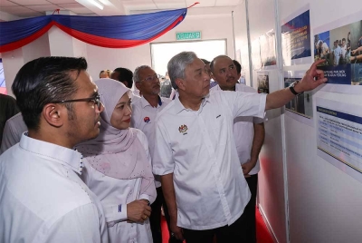 Ahmad Zahid (kanan) mendengar penerangan projek baik pulih PPR Melana Indah pada Lawatan Program Perumahan Rakyat (PPR) Melana Indah pada Ahad. - Foto: Bernama