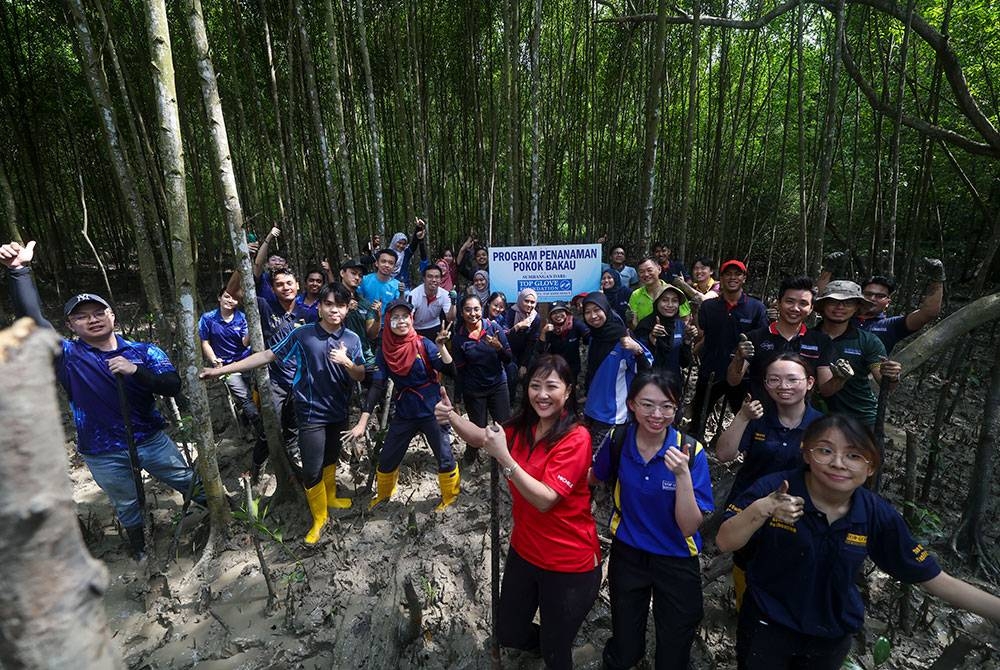 Kakitangan Top Glove Corporation Bhd yang terlibat menanam pokok bakau pada Program Penanaman Pokok Bakau Yayasan Top Glove di Taman Rekreasi Paya Bakau Kampung Sijangkang, Telok Panglima Garang pada Sabtu lepas.