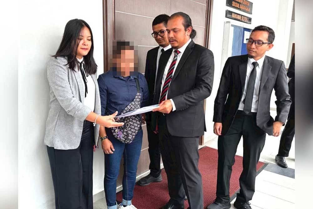 Alias (dua dari kanan) menunjukkan dokumen kepada Derfi (dua dari kiri) di Mahkamah Kota Bharu pada Isnin.