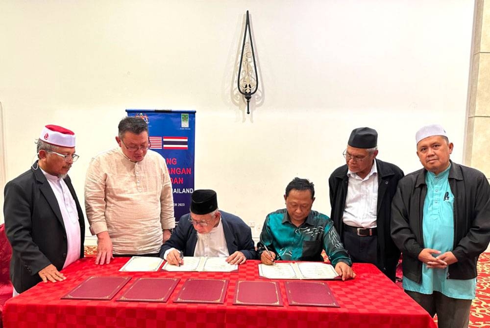 Mohd Azmi (tiga dari kiri) melihat dokumen yang selesai ditandatangani oleh wakil-wakil pada Isnin. - Foto ihsan pembaca