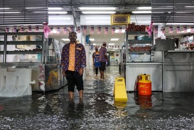 Air melimpah masuk sehingga ke ruang makan di sebuah restoran nasi kandar popular di Pulau Pinang. Foto: Bernama