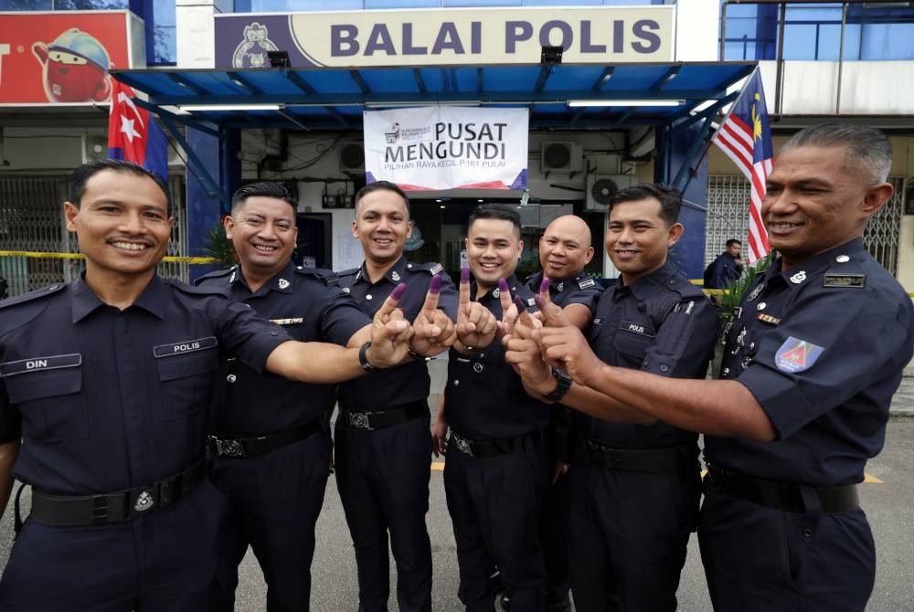 Anggota polis menunjukkan jari selepas menunaikan tanggungjawab mengundi awal bagi PRK Parlimen Pulai di Pusat Mengundi Balai Polis Kempas pada Selasa. - Foto Bernama.