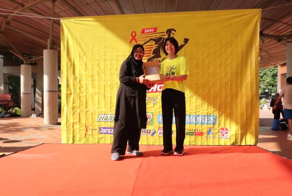 Penyelia Projek, Dr Ngan Sue Lin (kanan) menyerahkan sumbangan daripada penaja-penaja berupa peralatan perubatan dan vitamin kepada Norlina.