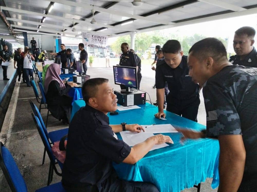 Sebahagian anggota dan pegawai Polis membuat semakan sebelum mengundi.