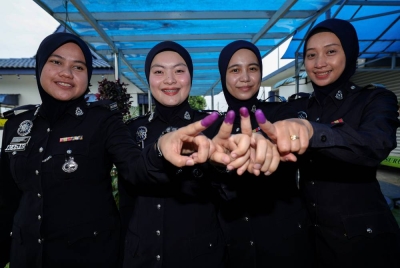 Anggota PDRM (dari kiri) Koperal Nur Fatihah Roselan, Koperal Nurazillah Naziah Maslin, Lans Koperal Nurfharah Shatiqah Hasmuramin dan Lans Koperal Norajijah Azis menunjukkan jari yang telah dicelup dakwat kekal selepas mengundi awal bagi PRK Parlimen Pulai, di Markas Pasukan Polis Marin Wilayah 2 Tampoi pada Selasa. - Foto Bernama.