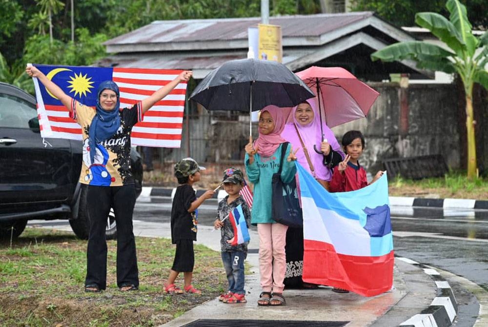 Noraini bersama anak-anaknya dan ibu saudara sanggup berhujan menanti ketibaan Yang di-Pertuan Agong, Al-Sultan Abdullah Ri’ayatuddin Billah Shah di pekarangan Kompleks Mahkamah Syariah Negeri Sabah, Kota Kinabalu.