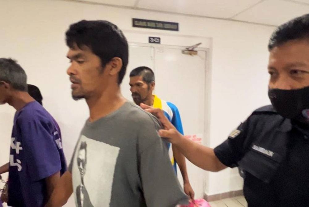 Tertuduh (dua dari kiri) dihadapkan ke Mahkamah Majistret di Kuala Terengganu pada Rabu atas dakwaan menceroboh rumah jiran.