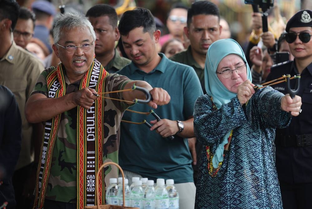 Al-Sultan Abdullah dan Tunku Azizah berkenan mencuba lastik guling. - Foto Bernama
