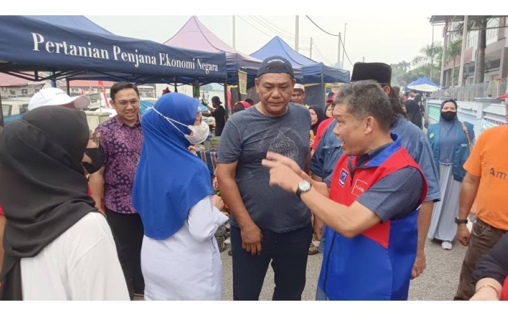 Calon PH dan BN, Nazri (kiri) tidak kekok bertemu dan beramah mesra dengan orang ramai di pasar malam di pekan Sungai Abong, Bakri,Muar. 