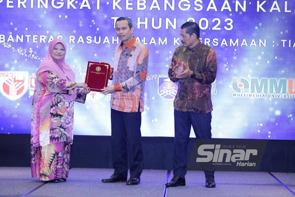 Azhar menerima resolusi daripada Junipah (kiri) ketika Majlis Perasmian Penutup Persidangan Penyelidikan Governans, Integriti dan Antirasuah pada Khamis.