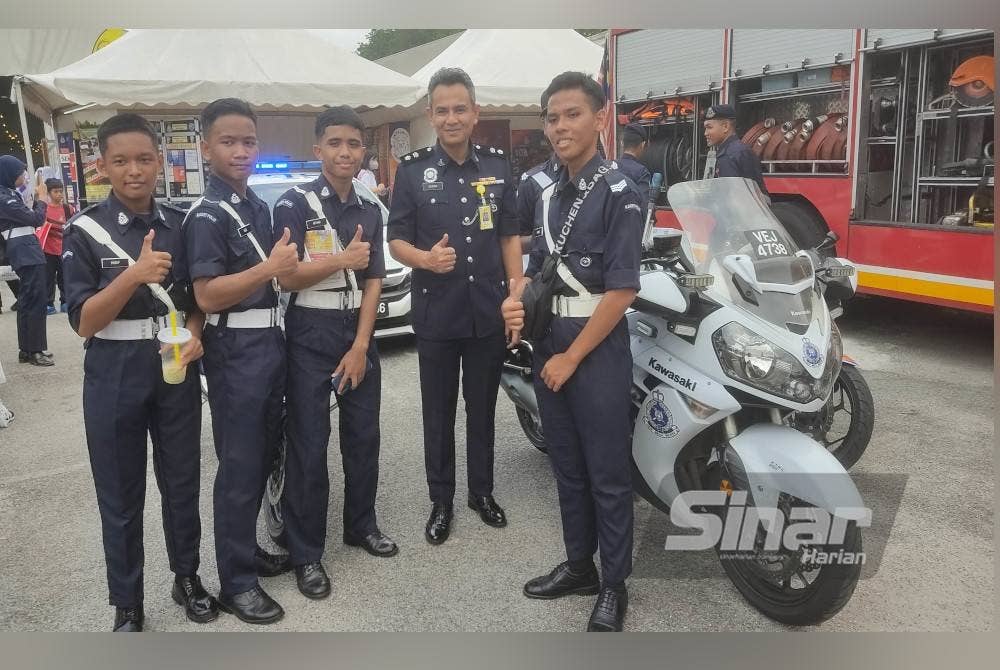 Muhamad Sajidan bergambar bersama Muhammad Nor Hakim (kanan) ketika lawatan di booth pameran Polis Diraja Malaysia di Karnival Pendidikan Sinar Bestari di Kompleks Karangkraf, Shah Alam pada Jumaat.