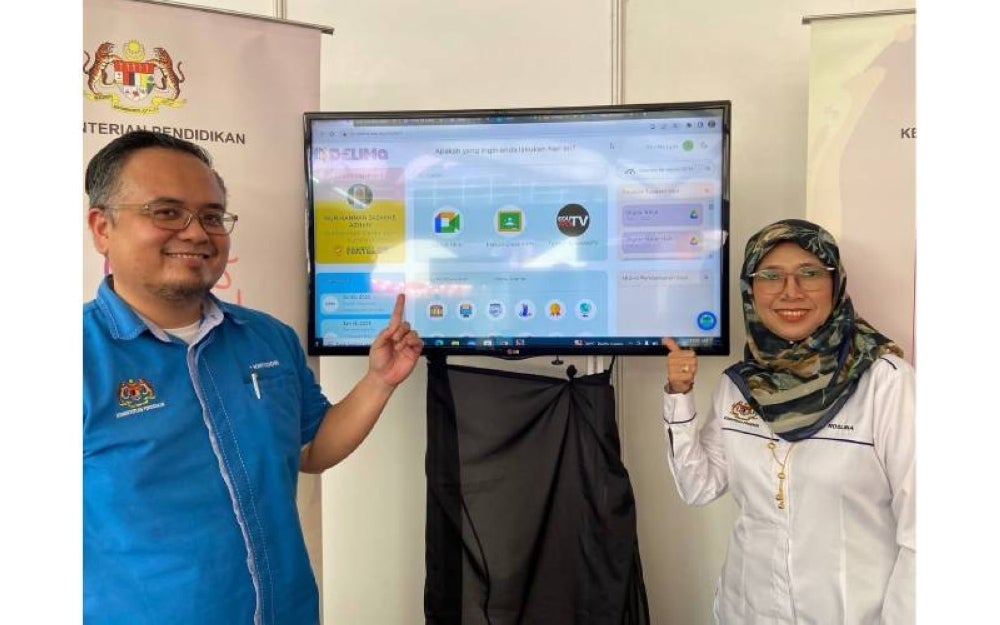 Wan Mohd Mohyeddin (kiri) bersama ketuanya, Roslina Ibrahim menunukkan platform DELIMa di reruai KPM.