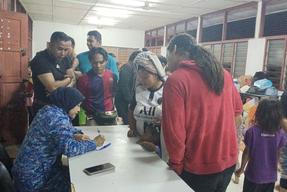 Mangsa banjir mendaftar di PPS yang dibuka di Dewan Orang Ramai Kampung Chinggong di sini susulan banjir kilat yang berlaku pada Jumaat. - Foto APM Muallim