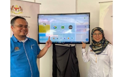 Wan Mohd Mohyeddin (kiri) bersama ketuanya, Roslina Ibrahim menunukkan platform DELIMa di reruai KPM.