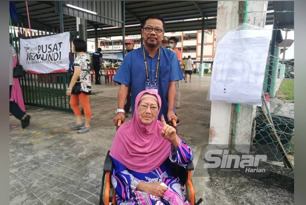Zulkifli mengiringi ibu mentuanya, Montiah selepas selesai mengundi di SJKC Tampoi, Johor Bahru pada Sabtu.