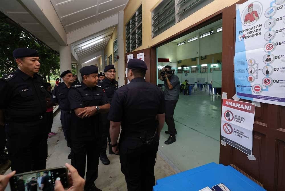 Ayob Khan (dua, kiri) meninjau proses mengundi bagi PRK Parlimen Pulai di Sekolah Menengah Kebangsaan (SMK) Taman Bukit Indah, pada Sabtu. - Foto Bernama