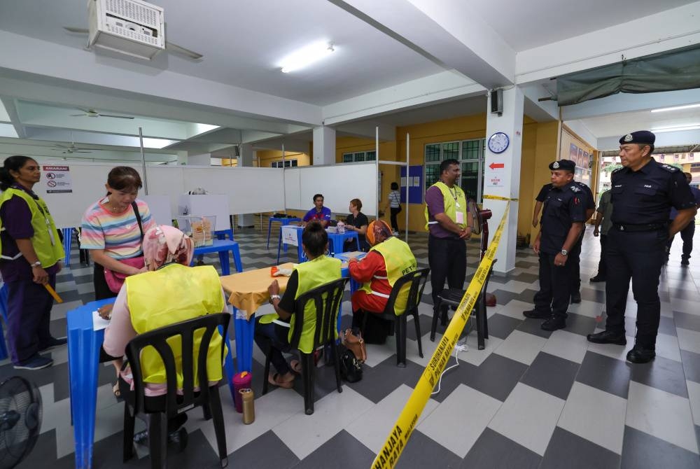 Ayob Khan (dua, kanan) meninjau proses mengundi bagi PRK Parlimen Pulai di Sekolah Menengah Kebangsaan Taman Bukit Indah pada Sabtu. - Foto Bernama