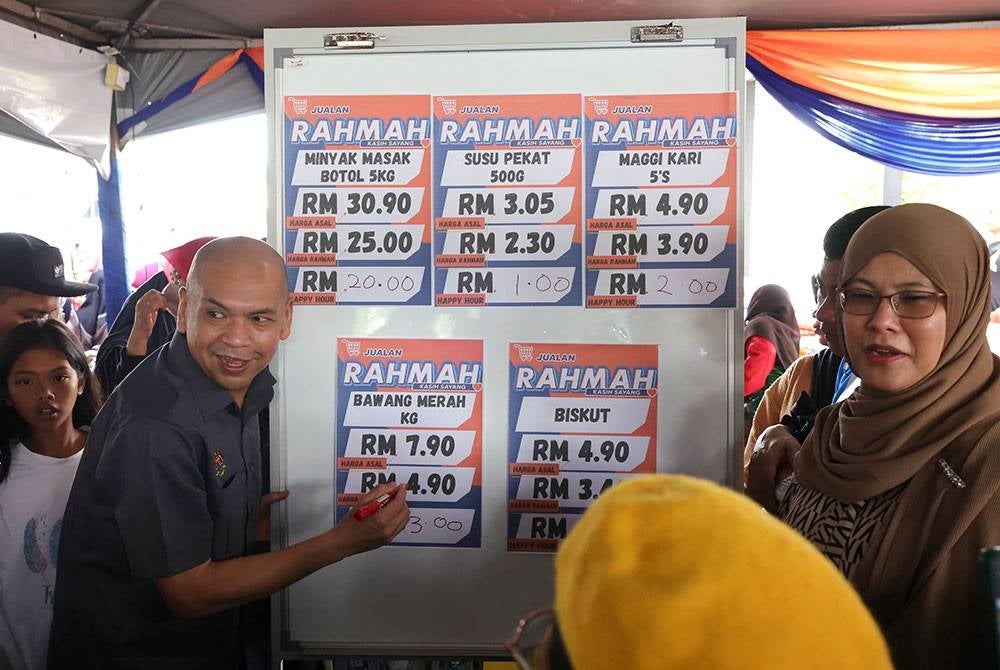 Armizan menunjukkan harga barang jualan Rahmah pada Program Jualan Rahmah Kampung Kawang di pekarangan Masjid Nurul Iman, Kampung Kawang, Papar pada Sabtu. - Foto Bernama