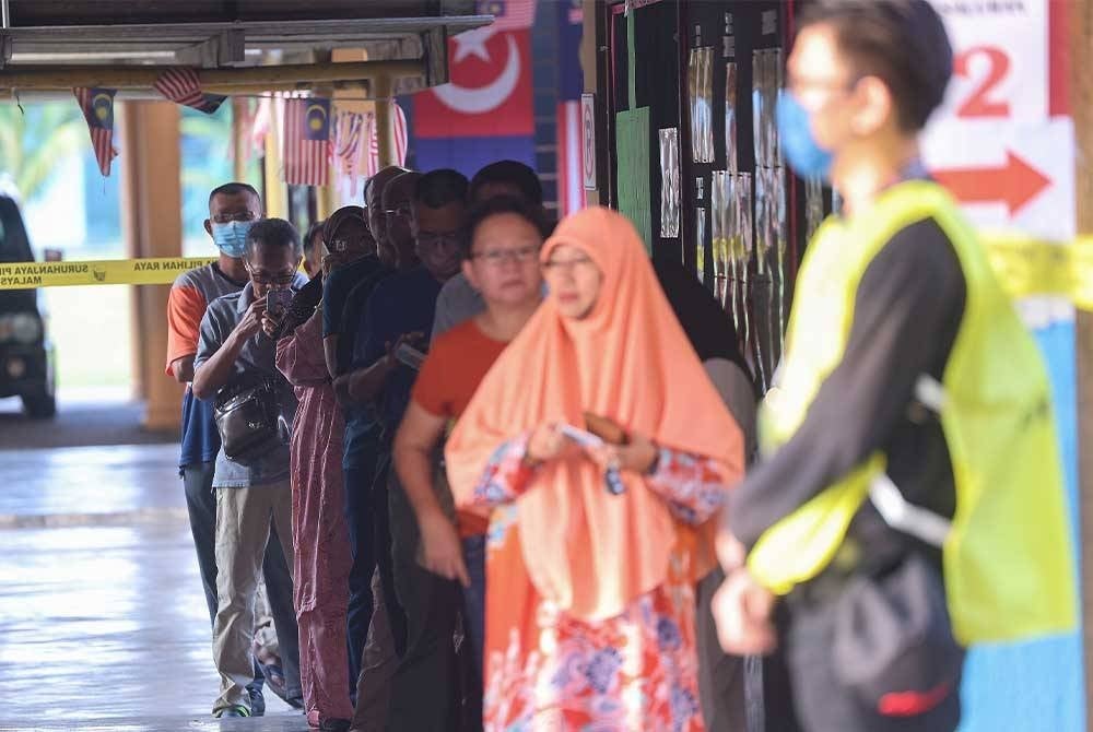 Pengundi beratur bagi menunggu giliran untuk menunaikan tanggungjawab sebagai pengundi di Sekolah Kebangsaan Simpang Jeram pada Sabtu. - Foto Bernama