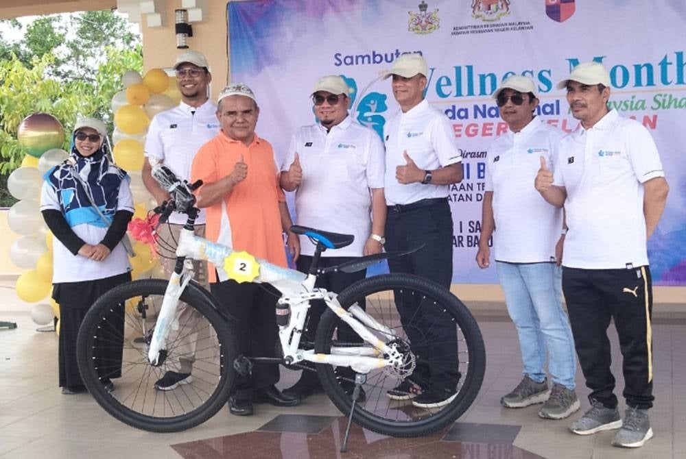 Hilmi (tengah) menyampaikan hadiah cabutan bertuah kepada pengunjung program Sambutan Wellness Month Peringkat Negeri Kelantan 2023 pada Sabtu.