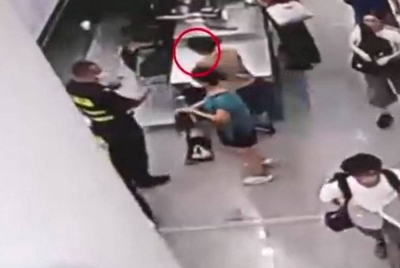 Imej litar kamera tertutup (CCTV) memaparkan pegawai kastam menahan seorang penumpang wanita selepas berkelakuan mencurigakan semasa pemeriksaan di Pelabuhan Futian. - Agensi