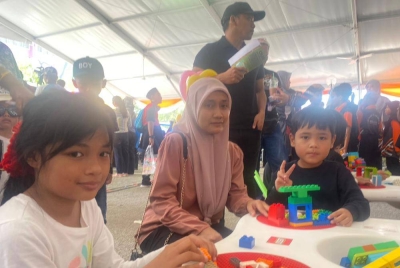 Siti Roshazar bersama dua orang anaknya dalam aktiviti permainan bongkah mini di Karnival Pendidikan Sinar Bestari pada Sabtu.
