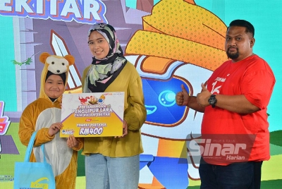 Nurashidah (dua dari kanan) menyampaikan hadiah wang tunai kepada adik Nur Azra selaku juara Pertandingan Penglipur Lara Cilik #alamsekitar X KDEBWM pada Sabtu.