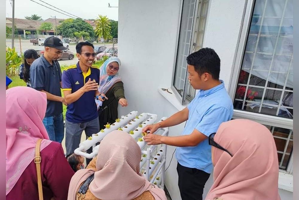 Chun Kuang menunjukkan tip penanaman sayuran melalui projek hidroponik ketika majlis penyerahan set hidroponik kepada golongan B40 di Kuantan.