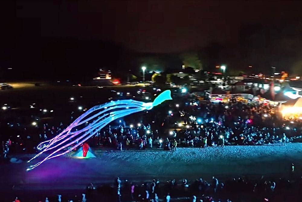 Layang-layang bercahaya yang dinaikkan pada waktu malam.