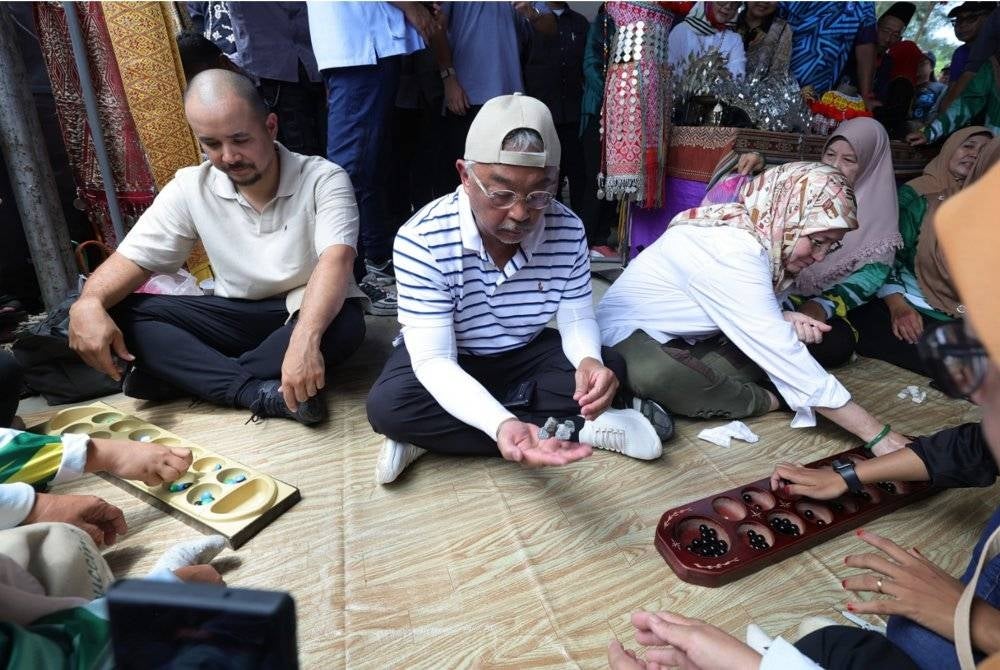 Al-Sultan Abdullah dan Tunku Azizah berkenan mencemar duli menyertai sukan rakyat ketika berangkat ke Pesta Keramaian bersama rakyat sempena Kembara Kenali Borneo di Pantai Bungai Bekenu pada Ahad. - Foto Bernama
