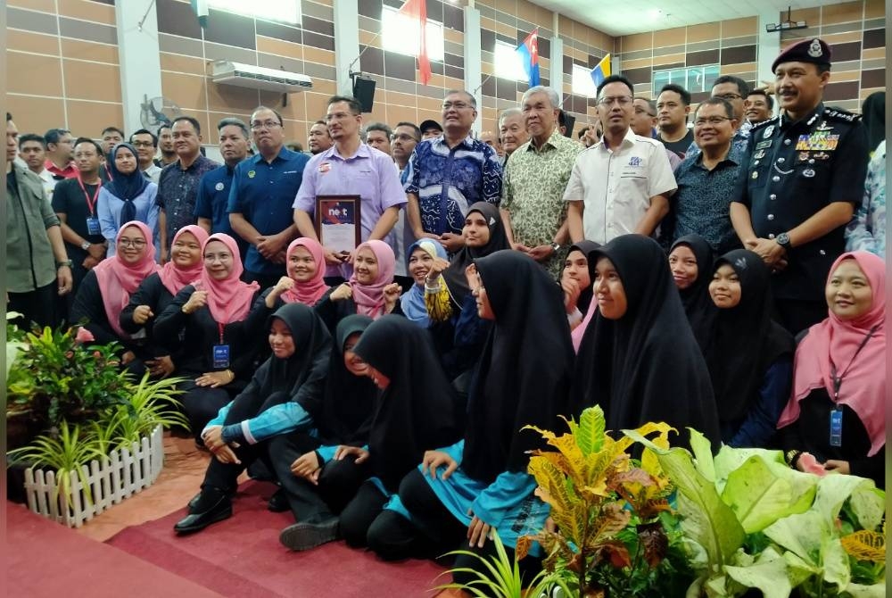 Ahmad Zahid (berdiri, empat dari kanan) bersama-sama peserta selepas menyempurnakan Perasmian Penutup Program Malaysia Next Leader Bagan Datuk di Dewan Dato' Lope Hashim, Bagan Datuk pada Ahad.