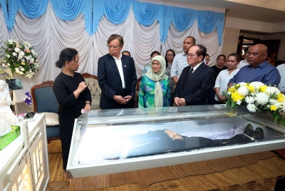 Abang Johari dan isteri, Puan Sri Jumaani Tuanku Bujang mendengar sesuatu daripada Marie Theresa (kiri), selepas memberi penghormatan terakhir kepada mendiang Ambrose.