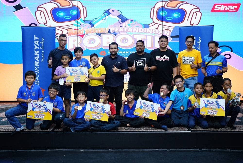 Pengurus Besar Jualan Iklan Sinar Harian, Airol Fadley Limin (berdiri, empat dari kanan) dan wakil Bank Rakyat (berdiri, empat dari kiri) bersama pemenang Pertandingan Robotik pada Ahad.