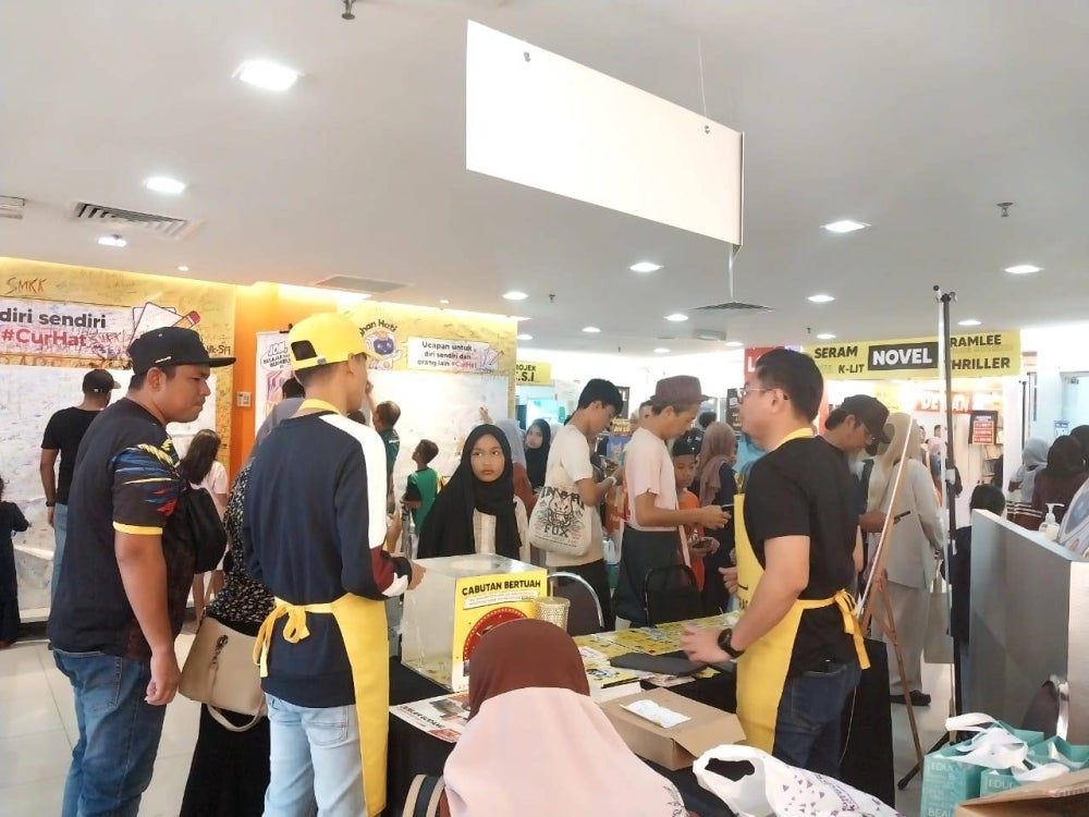 Pengunjung memenuhi kaunter pendaftaran kad VIP dalam Jualan Gudang Karangkraf 2023.