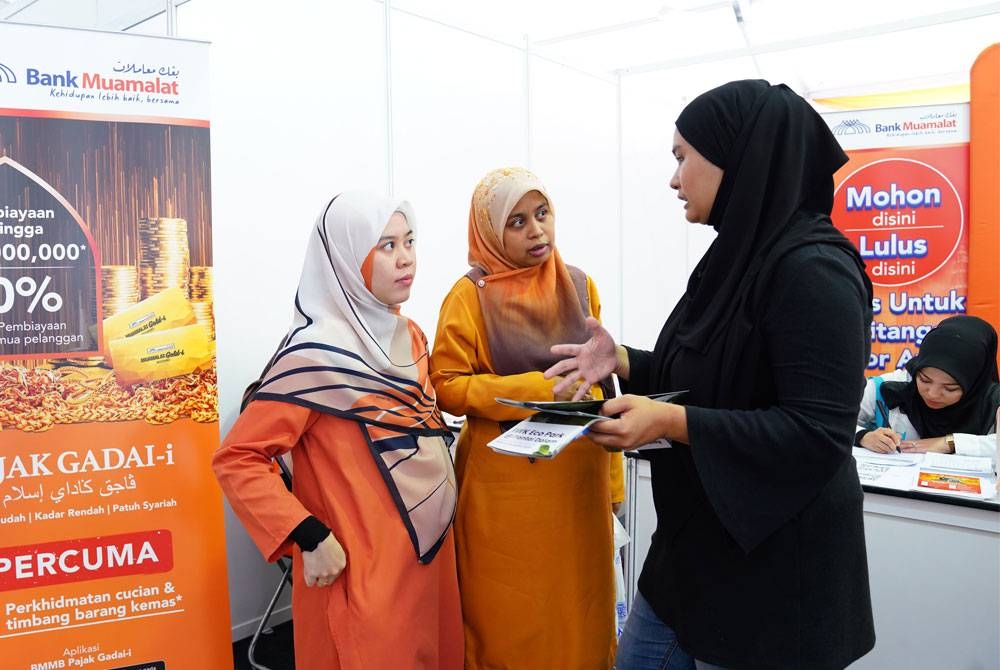 Penerangan mengenai pelbagai maklumat berkaitan perbankan Bank Muamalat disantuni pegawai yang bertugas.