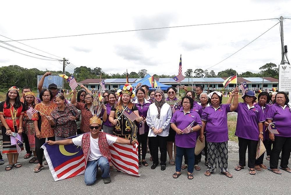 Raja Permaisuri Agong Tunku Azizah Aminah Maimunah Iskandariah berkenan bergambar bersama penduduk rumah panjang Peter sempena Kembara Kenali Borneo hari ini.
