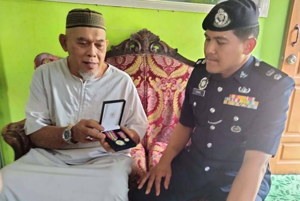 Mohd Yusof menunjukkan pingat yang diterima ketika bertugas dalam PPH.