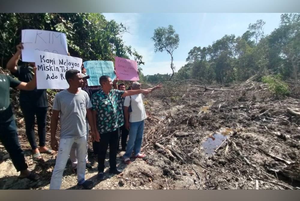 Wahid (dua dari kiri) menunjukkan kesan kerja-kerja pembersihan yang dilakukan secara haram oleh pihak tidak bertanggungjawab.