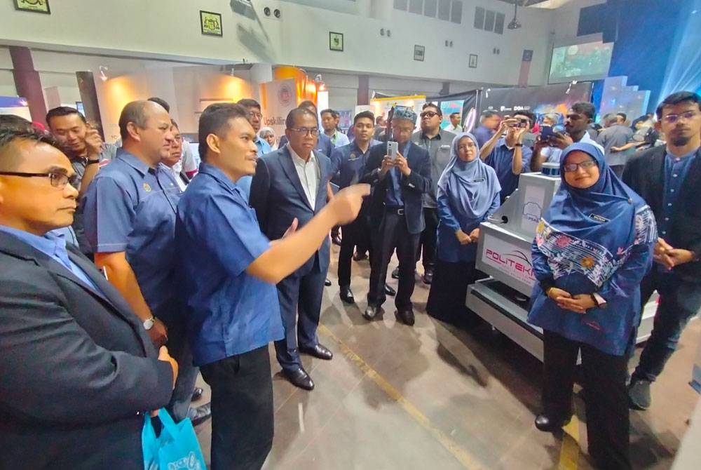 Mohamed Khaled (empat dari kiri) melawat ruang pameran dan diberikan taklimat oleh petugas program.