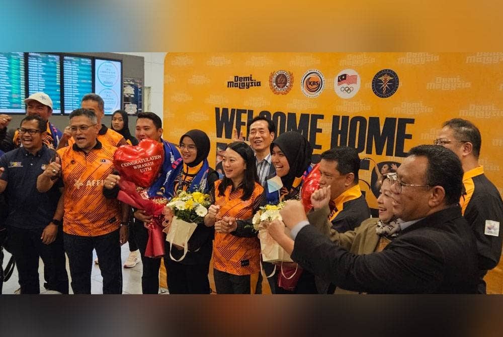 Hannah (tengah) menyambut kepulangan skuad boling padang termasuk Nabilah dan Aleena dari Kejohanan Dunia di Klia2 pada Isnin. - Foto: Agensi