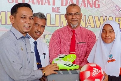 Mohd Azlan Helmi (kanan) memyampaikan sumbangan peralatan sukan kepada Nurfarisha Karmila (kanan) yang akan beraksi di Kejohanan Pearl Cup di Pulau Pinang.