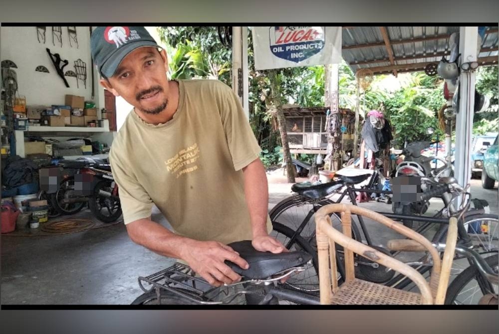 Mohd Hafizal menunjukkan pelana basikal diperbuat daripada kulit yang dipasang di basikal jenama Raleigh miliknya.