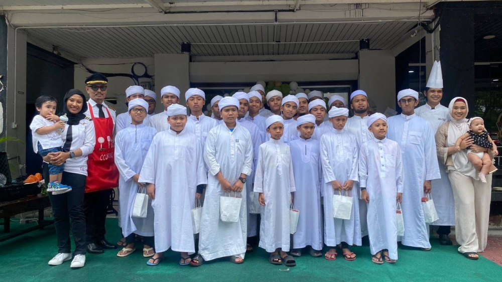 Azrin (tiga dari) dan isterinya, Latun Noralyani Meor Aminudin (dua dari kiri) bersama pelajar Maahad Tahfiz al-Quran al-Munawwarah, Seksyen 27 turut hadir bagi sesi bacaan doa selamat dan kesyukuran di Majlis Perasmian Pembukaan Captain Chef Cafe yang bertempat di Seksyen 27, di sini, pada Selasa.