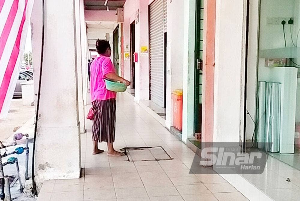 Seorang pekerja warga Menyamar membawa bakul bawang sebelum naik ke tingkat atas kedai makan.