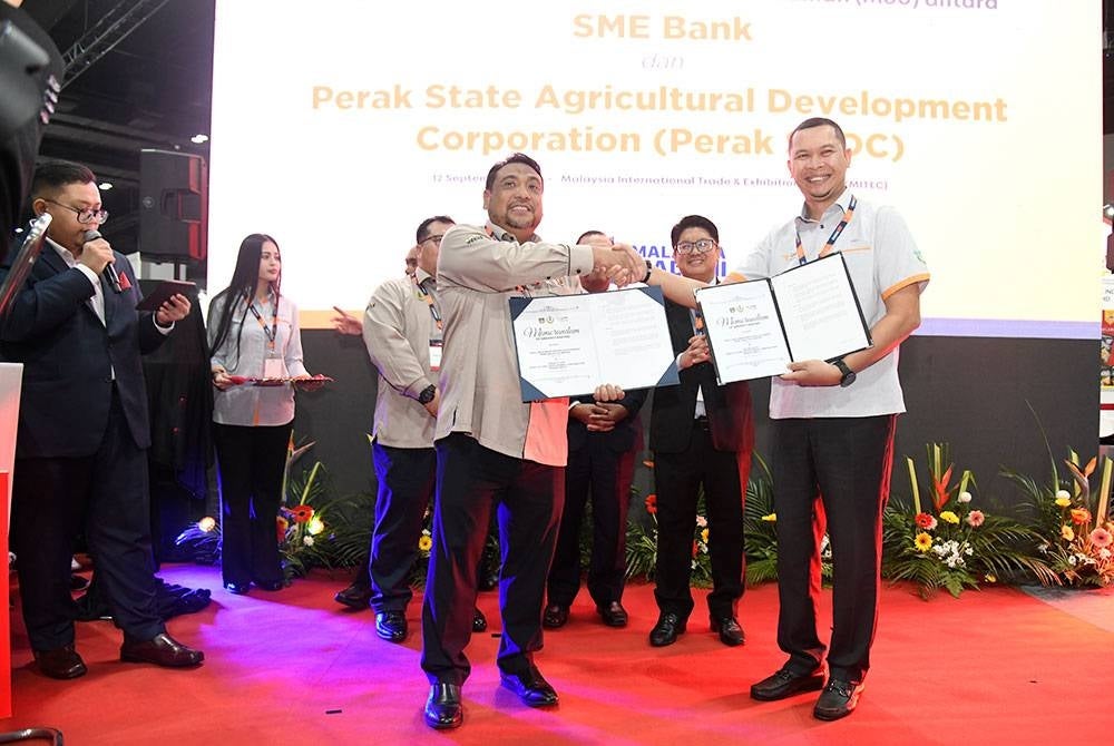 Aria (kanan) dan Yahanis (kiri) menunjukkan dokumen MoU sambil disaksikan Ewon (tengah) semasa Majlis Pertukaran MoU yang diadakan semasa MIHAS 2023, di Kuala Lumpur pada Selasa.