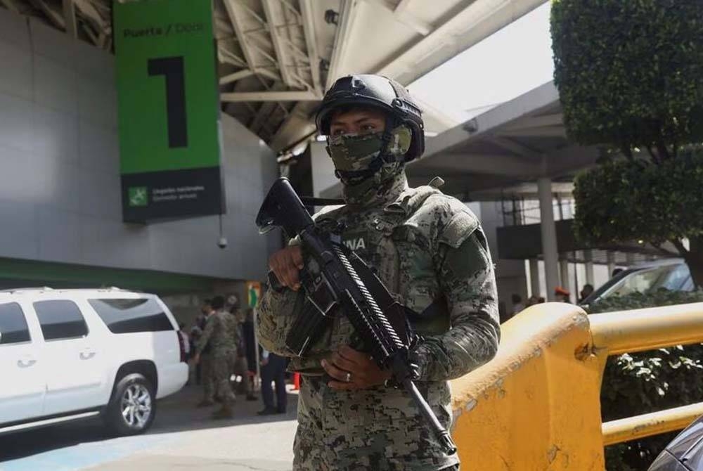 Seorang anggota pasukan keselamatan berkawal di luar Lapangan Terbang Antarabangsa Mexico City selepas seorang yang disyaki perompak melepaskan tembakan ke arah polis,di Mexico City pada Selasa. - Foto: Reuters
