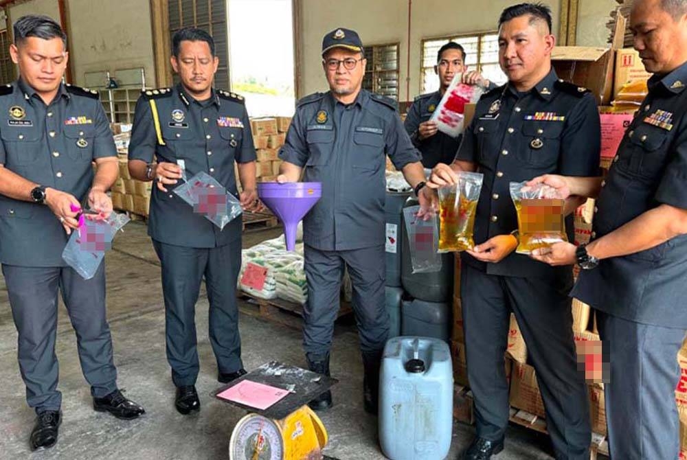 Azman (tengah) menunjukkan peralatan yang digunakan suspek dalam kegiatan dipercayai penyeludupan minyak masak di Pasir Puteh.